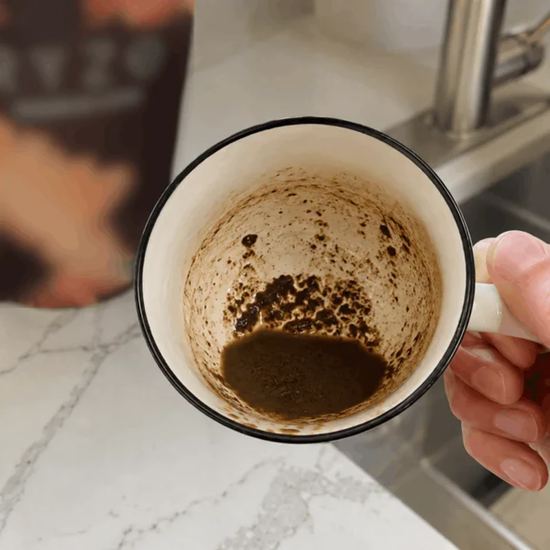 Emptied competitor mug showing thick sludge and grit at the bottom.